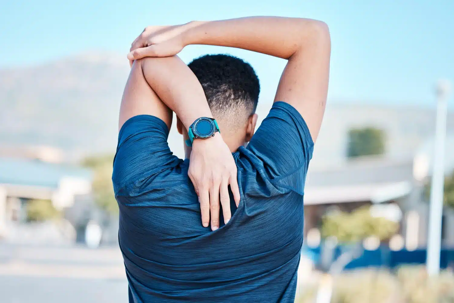 Man stretching shoulders to relieve tension headache