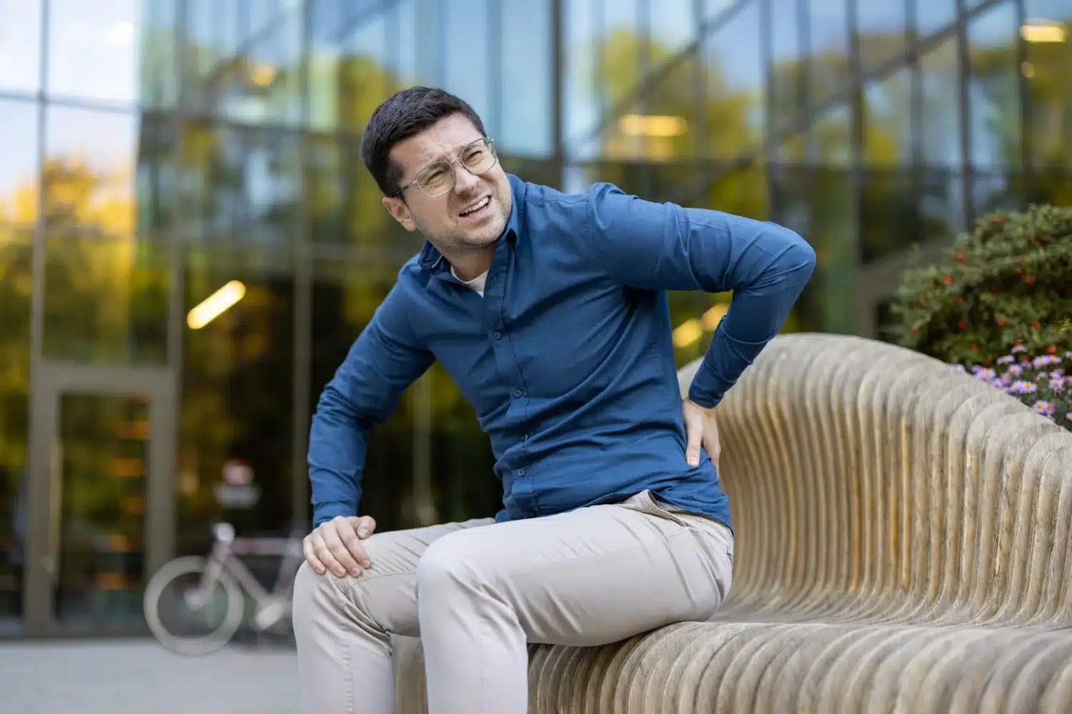 Person stretching lower back after long drive to relieve sciatica pain
