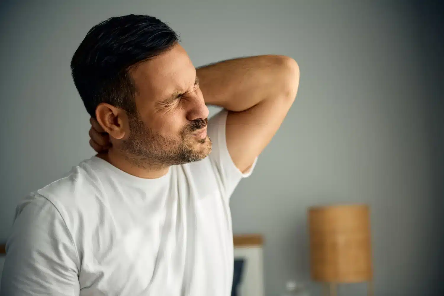 Man stretching shoulders to relieve tension headache