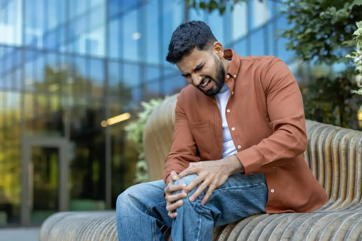 Man holding his knee while experiencing knee pain